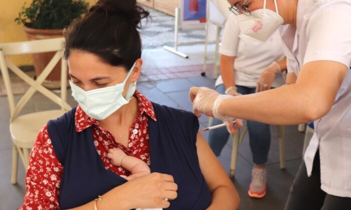 Kundakta bebeğiyle aşı oldu