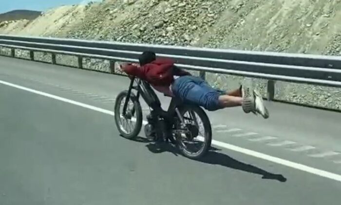Motosikletin üstüne yatan sürücünün tehlikeli yolculuğu kamerada