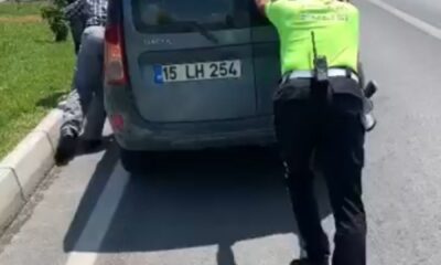 Trafik polisi, yolda kalan aracı iterek sürücüye yardım etti