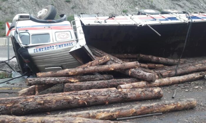 Yan yatan kamyondaki tomruklar otomobilin üstüne devrildi: 2 yaralı