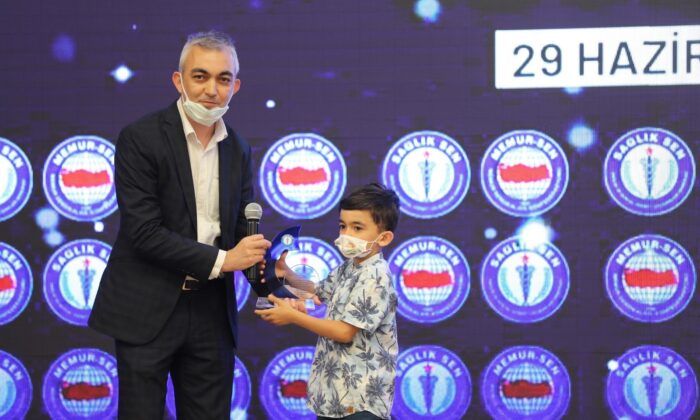 Aldığı plaketi oğluna verdi