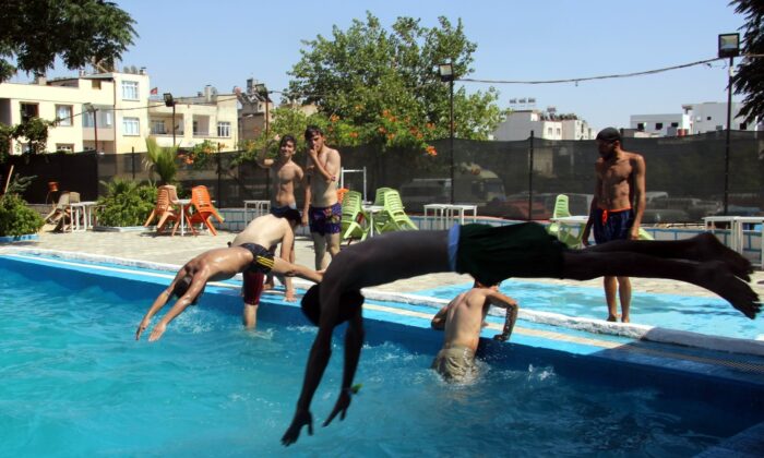 Aşırı sıcaktan bunalan gençler havuzda serinliyor