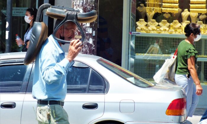 Sıcaktan korunmak isteyen vatandaştan ilginç yöntem: Kafasının üstünde koltukla yürüdü