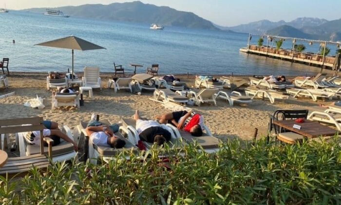 Uyarıları dikkate almayan turistler sahilde uyuyor